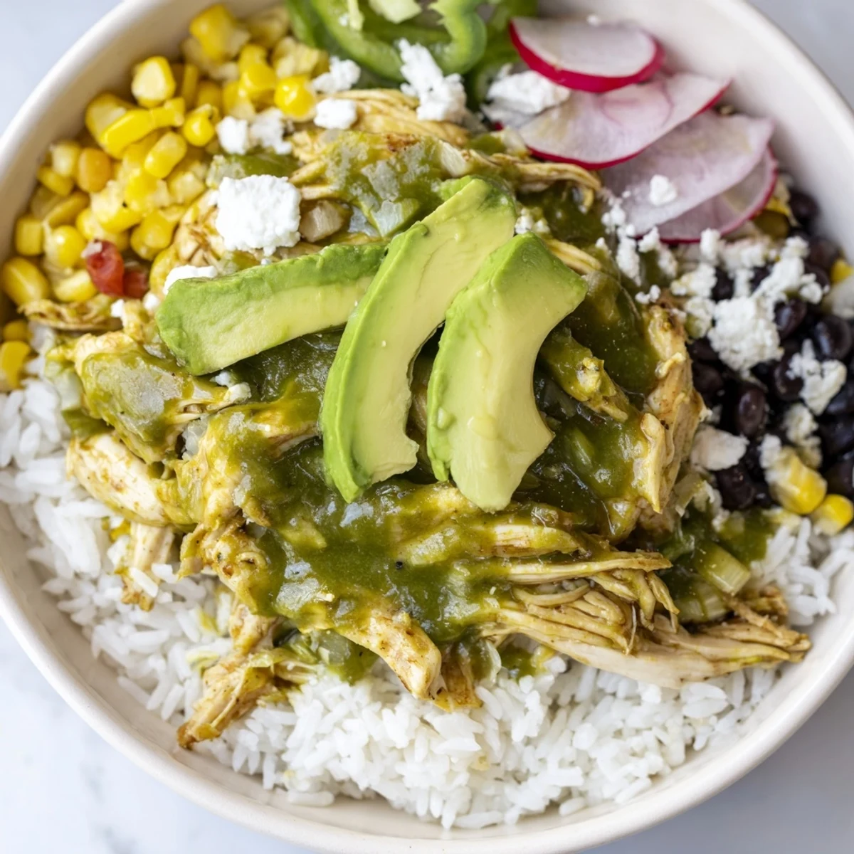 Steaming Green Enchiladas Rice Bowl overflowing with chicken, fresh cilantro, and creamy avocado slices.