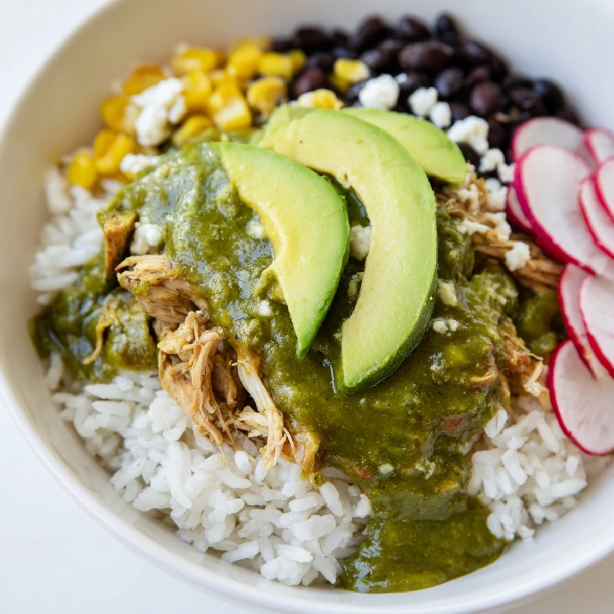 Flavorful Green Enchiladas Rice Bowl, a gluten-free meal with warm spiced chicken and black beans.