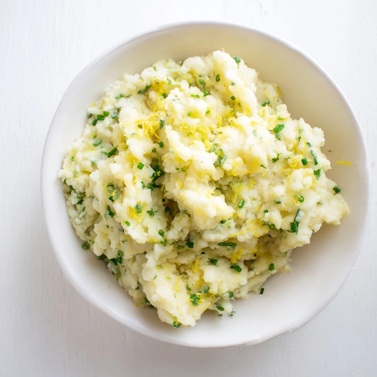 Freshly mashed cauliflower with garlic: a vibrant, low-carb side, garnished with herbs.