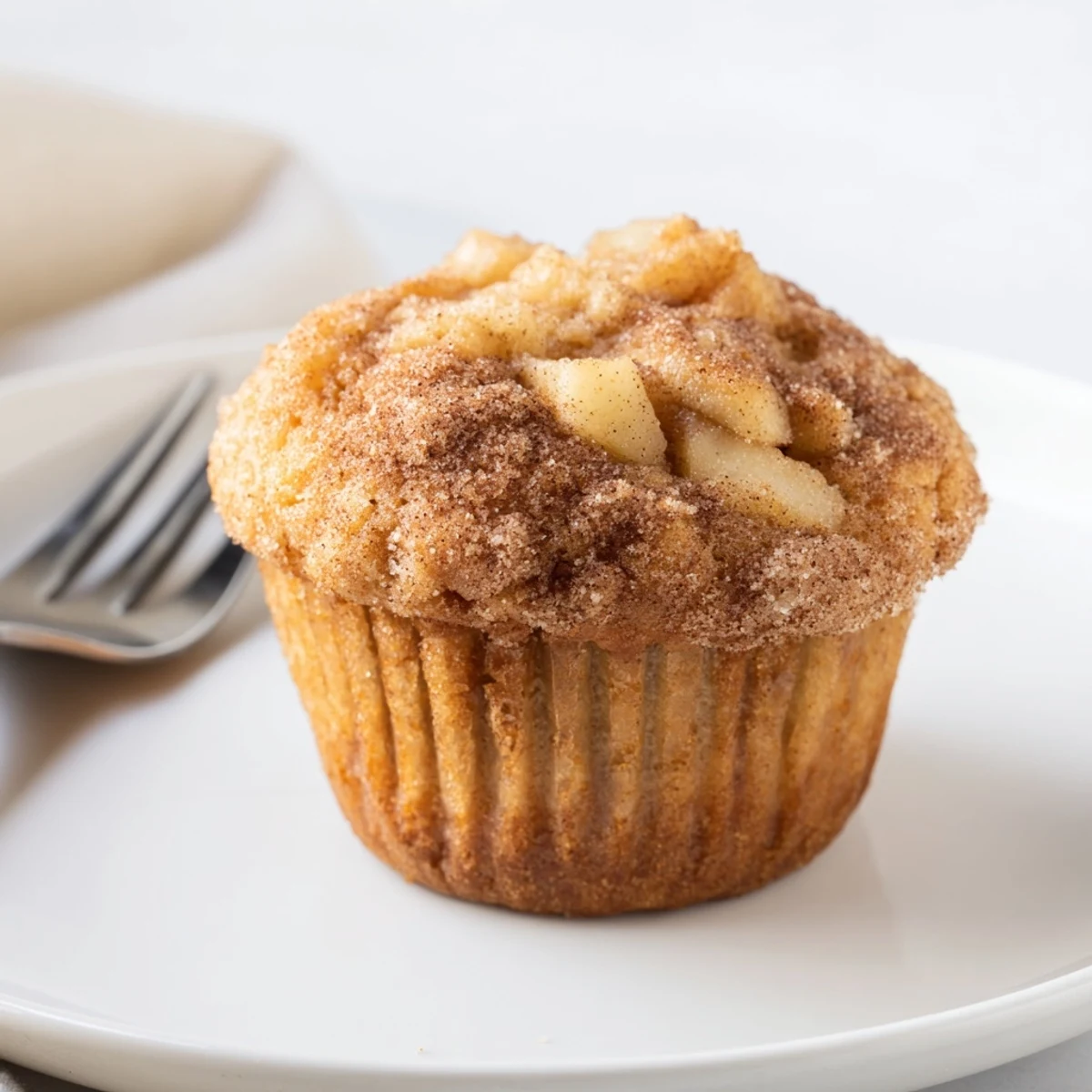 Freshly baked cinnamon apple muffins, golden-brown and delightfully fragrant, ready to enjoy.