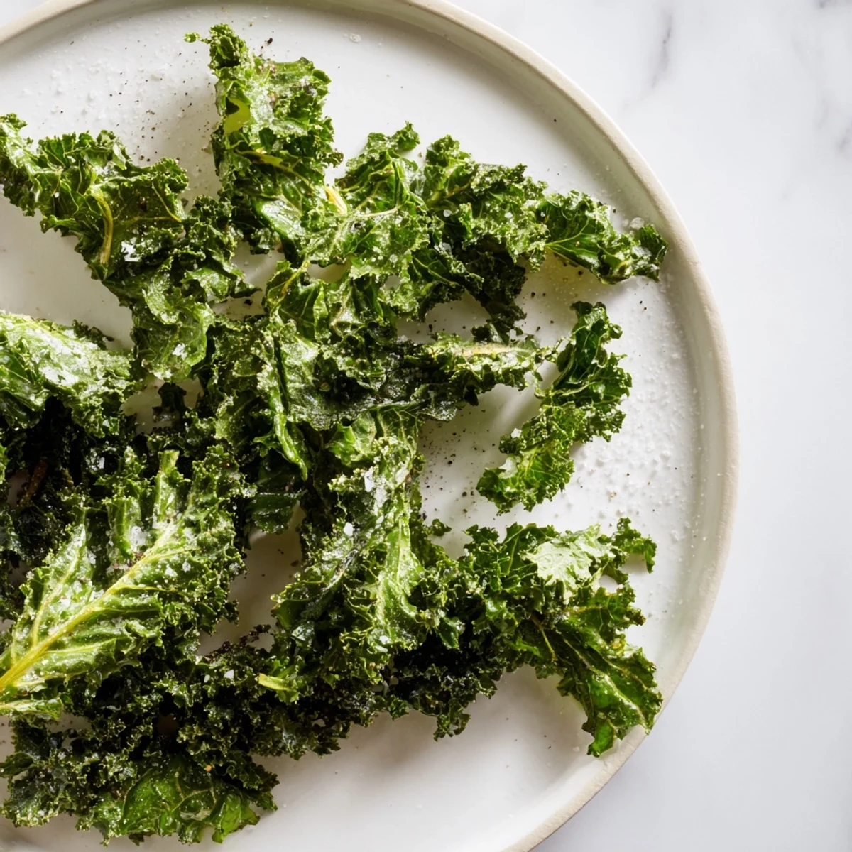 Golden, crunchy baked kale chips, delightfully salted, arranged on a parchment-lined baking sheet.