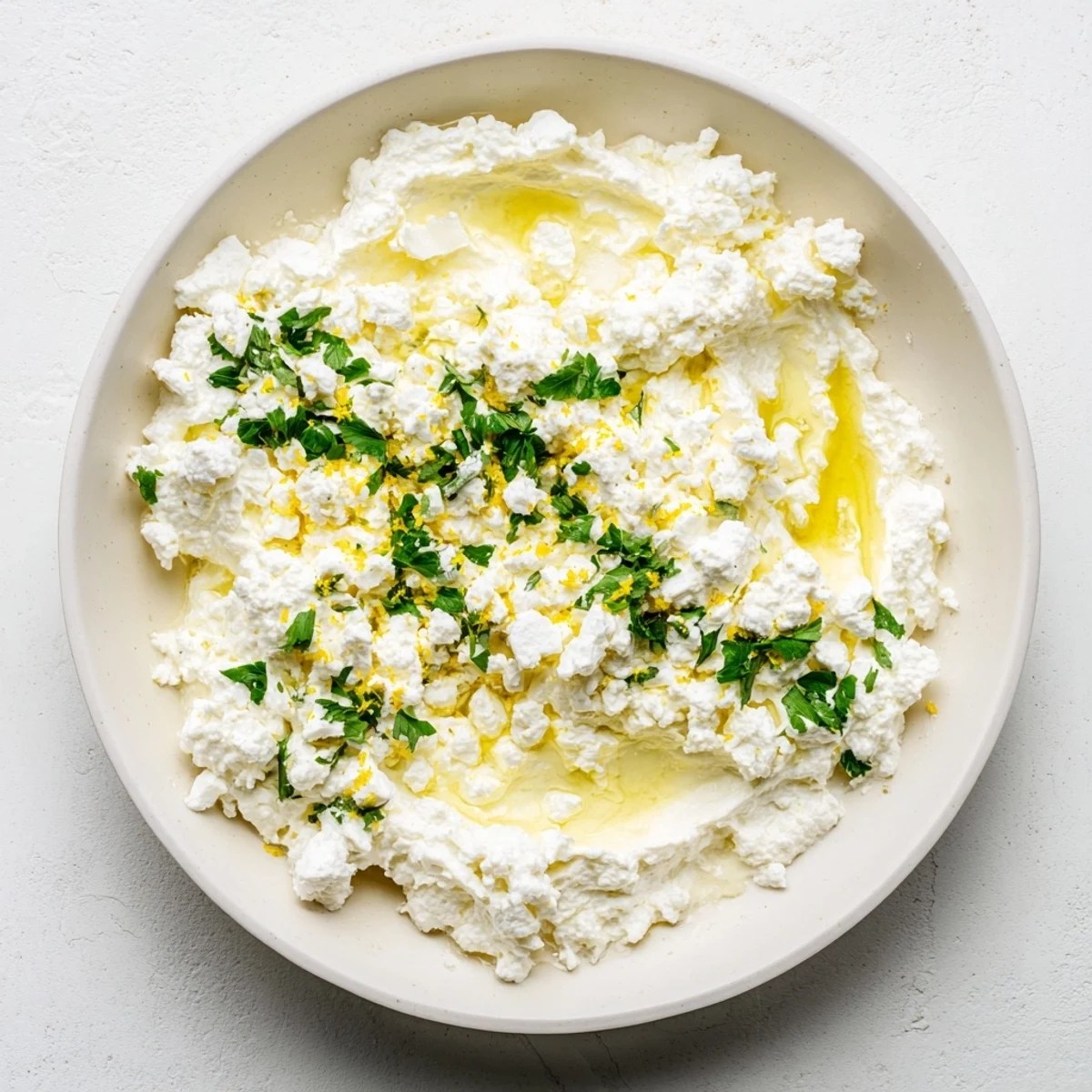 Creamy whipped feta dip, speckled with herbs, ready for dipping vegetables and enjoying.