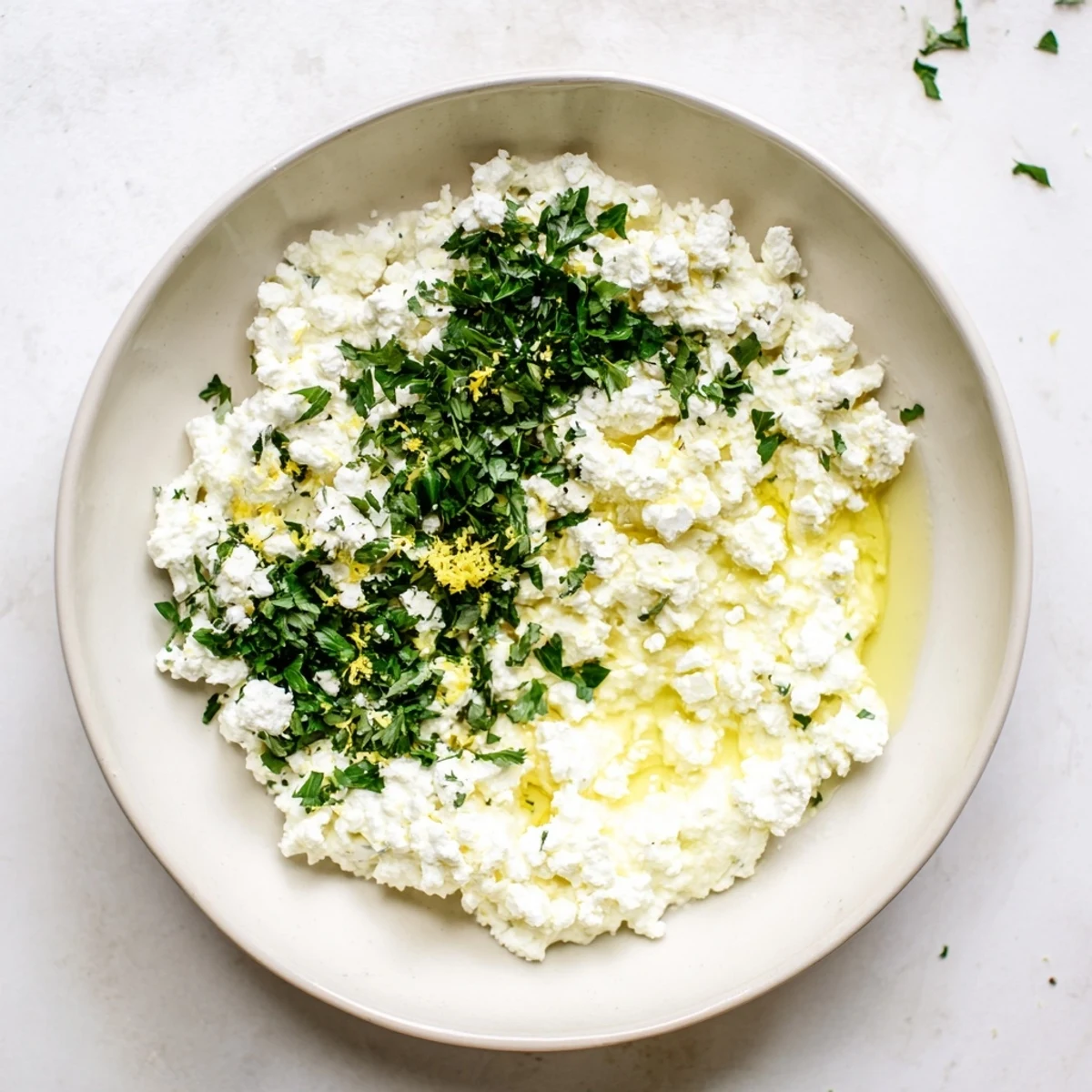 Golden pita chips surrounding a bowl of vibrantly seasoned whipped feta cheese appetizer.