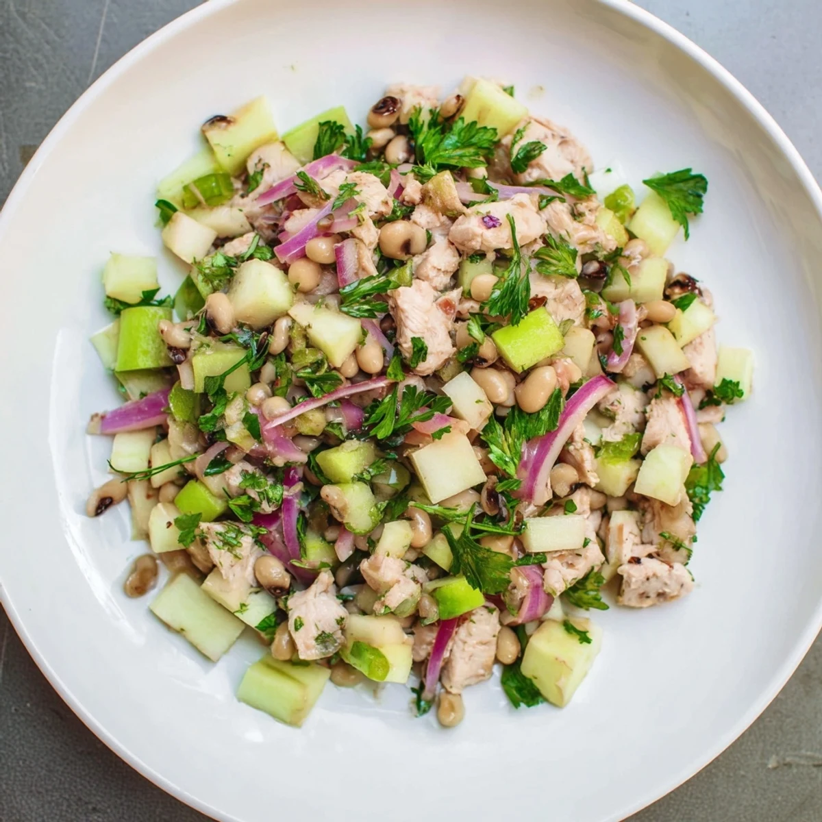 Chicken and Apple New Years Luck Salad, a vibrant mix of chicken, apples, and black-eyed peas awaiting diners.