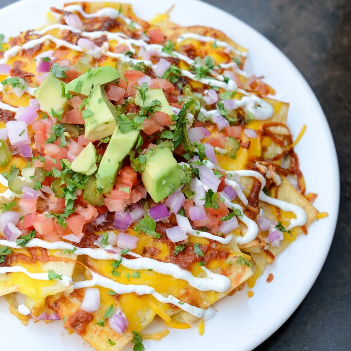Golden, baked pasta chips nachos, layered with melted cheese and fresh, vibrant toppings.