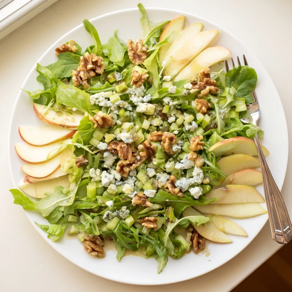 Crisp apple slices and toasted walnuts tossed with mixed greens and a tangy vinaigrette, ready to serve as a light appetizer.  