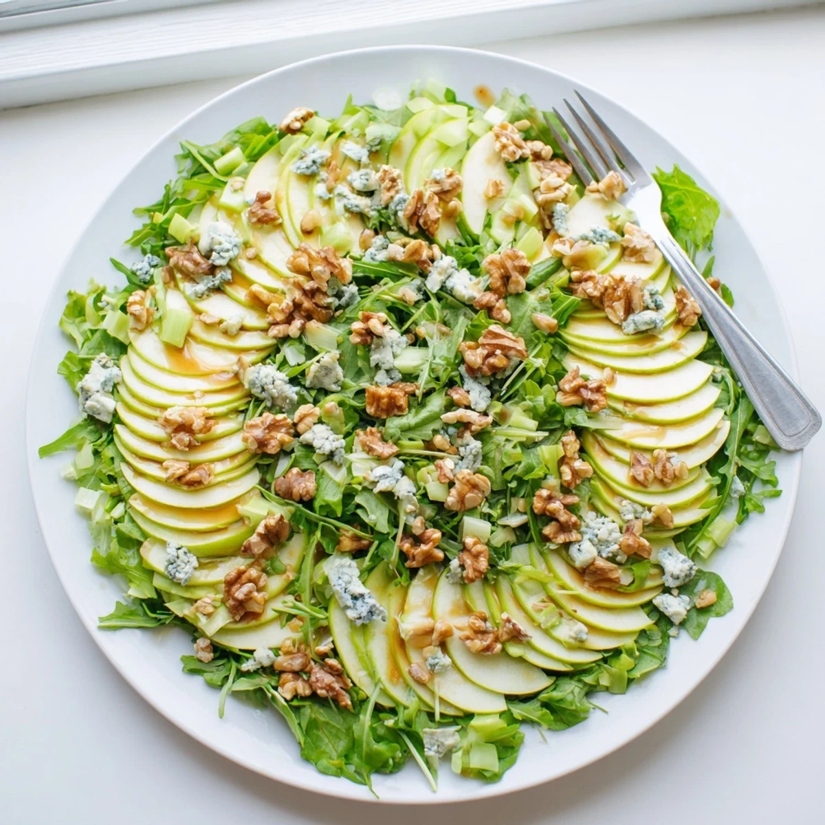 Apple and Walnut Salad with crumbled blue cheese, crisp apples, and crunchy walnuts on a bed of fresh greens.  