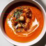 A vibrant bowl of Creamy Roasted Garlic Tomato Soup, perfect for a cozy, comforting meal.