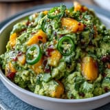 Creamy avocado dip with sweet mango and spicy jalapeño, ideal for festive Mexican appetizers.  