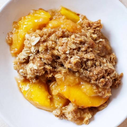 Golden, bubbly Warm Peach Cobbler with a crispy oat topping, perfect for dessert tonight.