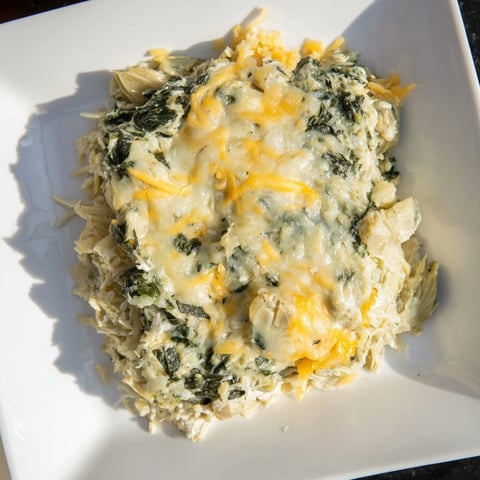 Golden, bubbling Cheesy Spinach and Artichoke Bake, a comforting vegetarian casserole topped with melted cheese.