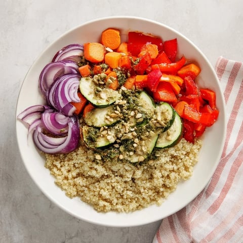 Fluffy quinoa bowl with roasted vegetables and vibrant herb dressing, a colorful and healthy meal.