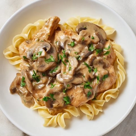 Golden chicken strips in creamy, mushroom-filled Creamy Chicken Stroganoff, ready to serve over noodles.