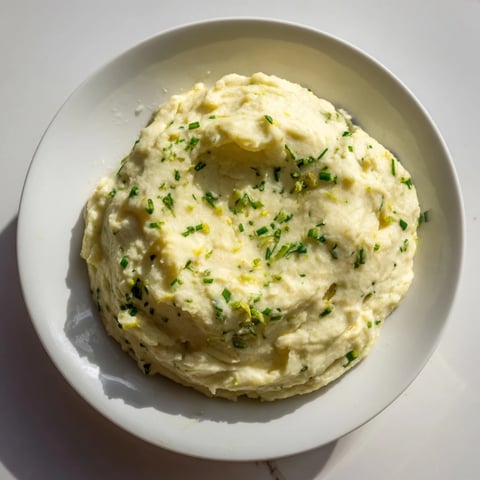 Creamy cauliflower mash with garlic and herbs, a comforting gluten-free side, ready to serve.