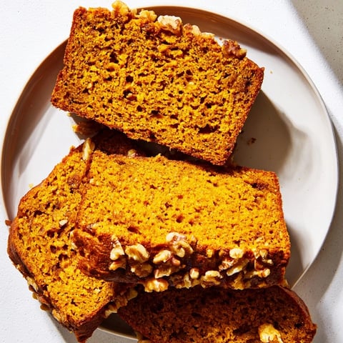 Steaming mug of pumpkin bread, perfectly spiced and ready to enjoy with a warm drink.