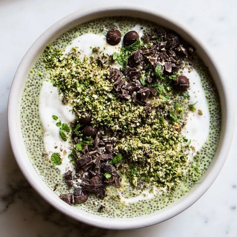 Vibrantly green Grinch Green Mint Matcha Breakfast Chia Pudding, topped with cacao nibs and fresh mint, ready to eat.
