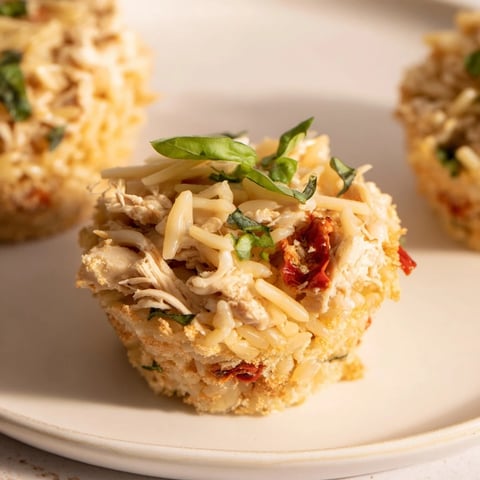 Golden-brown Marry Me Chicken Sushi Bake Cups, bubbly cheese topping a savory pasta and chicken filling.