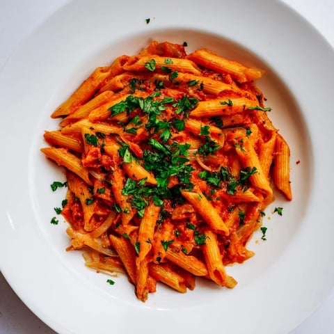 Vibrant photo of Penne all'Arrabbiata: Spicy red pasta coated in a rich, flavorful tomato sauce.