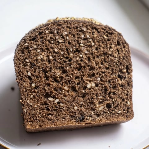Crusty Estonian Leib Sourdough loaf, dark and aromatic, ready to be sliced for serving.