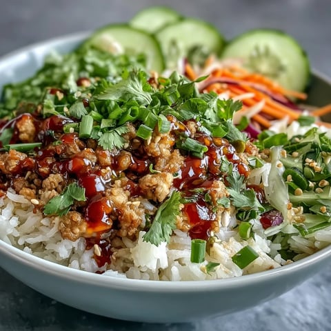 Steamed rice and saucy turkey topped with crunchy carrots and cucumbers in Bang Bang Ground Turkey Rice Bowls.