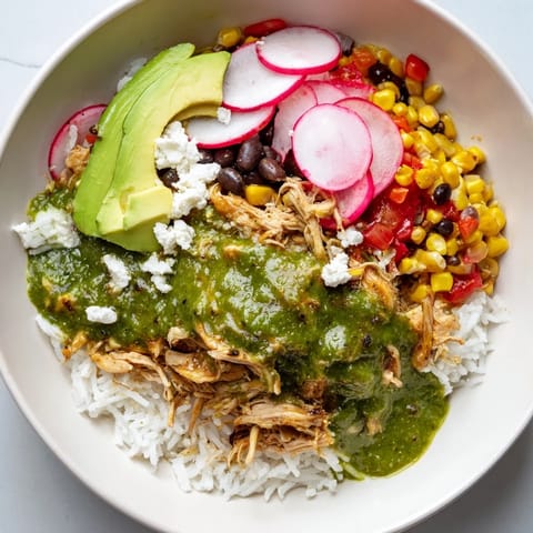 A close-up view of a Green Enchiladas Rice Bowl, showcasing colorful Tex-Mex ingredients in a bowl.