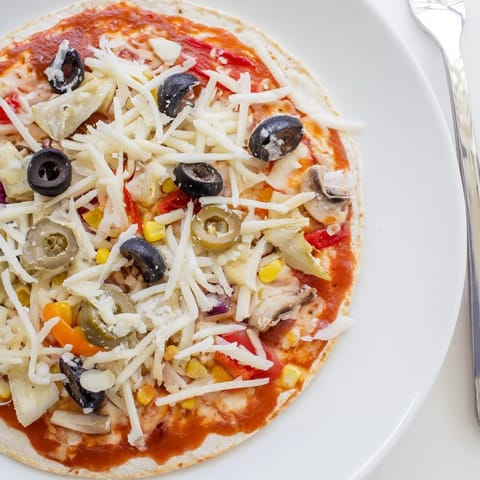 A close-up of a golden brown tortilla pizza, showcasing the delicious pantry topping options.