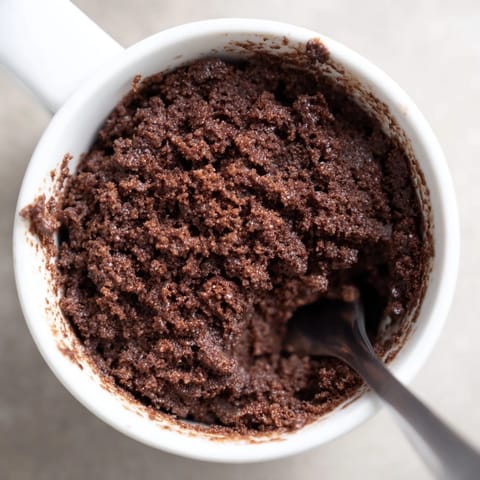 A fluffy, single-serving Microwave Mug Cake, perfectly cooked and topped with a scoop of ice cream.