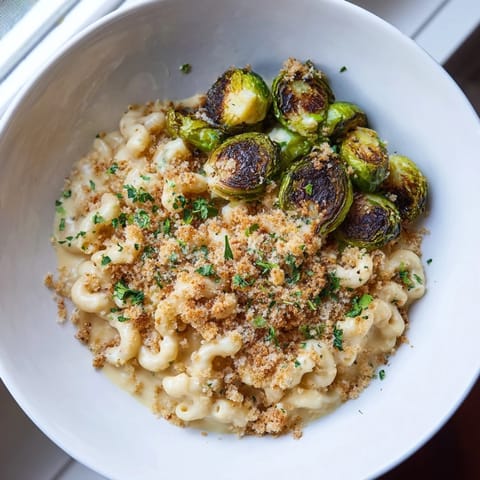 Crispy edges and melty cheese make this sheet pan mac and cheese and Brussels sprouts a flavorful treat.