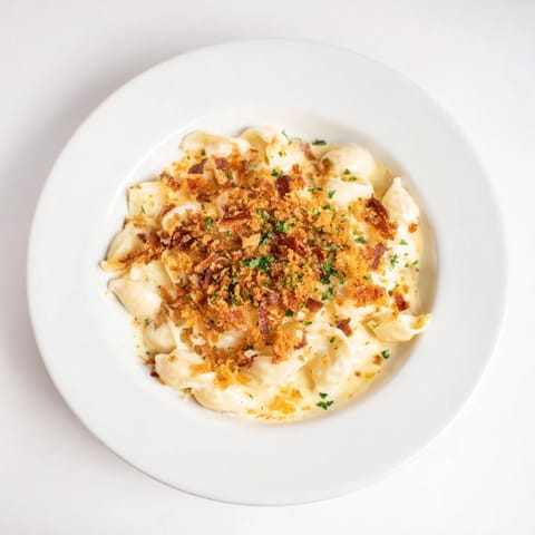 A close-up shot of baked sheet pan mac and cheese, speckled with savory bacon.