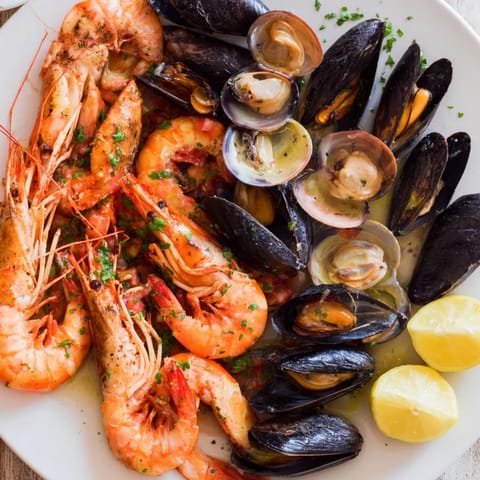 Plump shrimp and scallops nestled in a shellfish & seafood medley, served with bright lemon wedges and herbs.