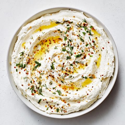 This appetizing Angel Wings Whipped Feta Dip presents a swirl of honey and fresh mint atop a smooth dip.