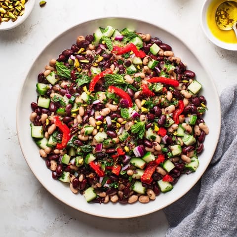 This delicious Dense Bean Salad with Dubai Chocolate Notes features tender beans topped with nuts and cacao.