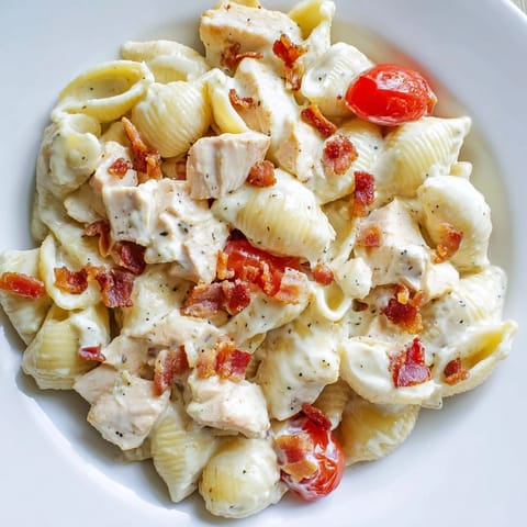 Golden-brown grilled chicken and smoky bacon pieces are tossed with pasta shells, fresh romaine, and red onion in a creamy mayonnaise dressing for this BLT Chicken Pasta Salad.