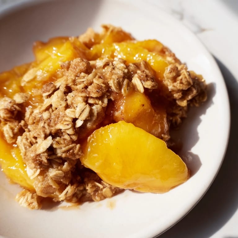 A close-up image shows steaming Warm Peach Cobbler, served warm and ready to enjoy.