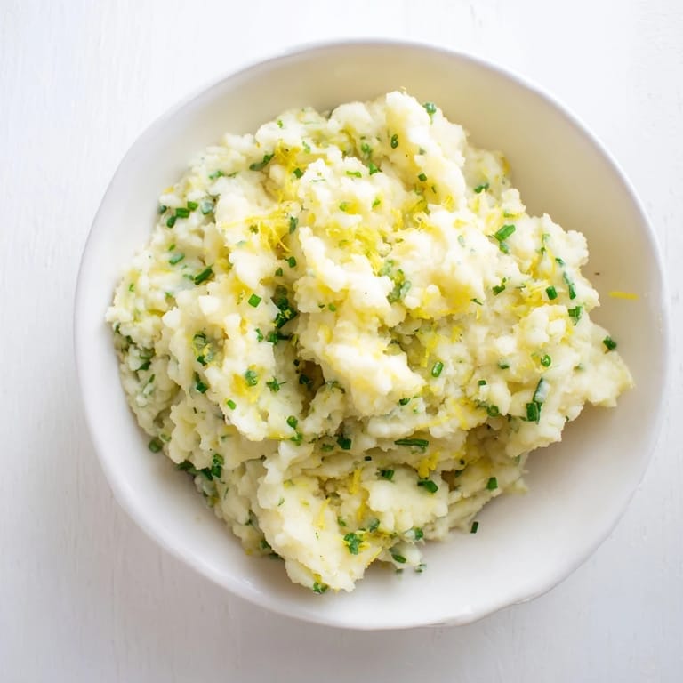 Freshly mashed cauliflower with garlic: a vibrant, low-carb side, garnished with herbs.
