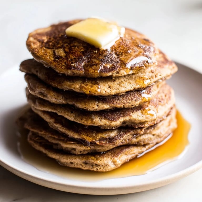 A stack of fluffy Gingerbread Pancakes, smelling of warm spices, promises a cozy breakfast treat.