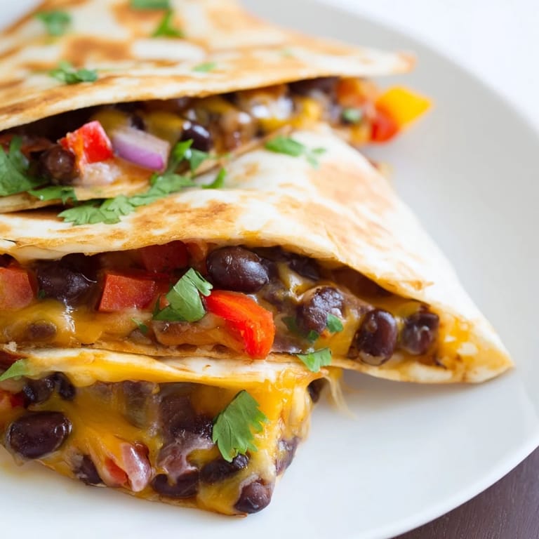 A close-up of a sizzling Black Bean Quesadilla with melted cheese and hints of cumin and paprika.