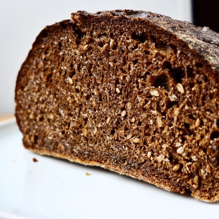 Close-up of a rustic Estonian Leib Sourdough loaf, showcasing its dark, dense texture and caraway seeds.