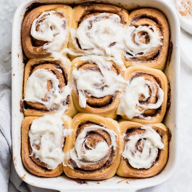 Homemade pumpkin cinnamon rolls with pillowy dough, a gooey cinnamon swirl, and a generous drizzle of sweet frosting.
